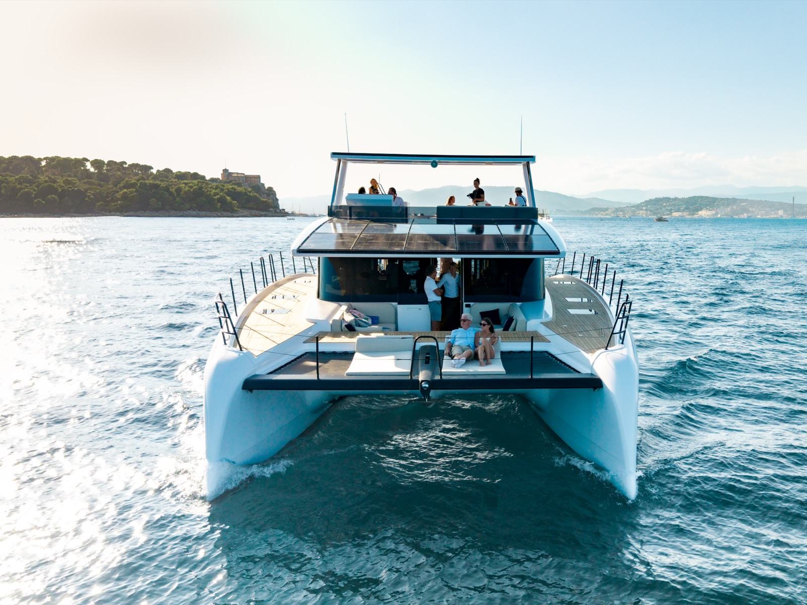 Catamaran head on with guests on deck